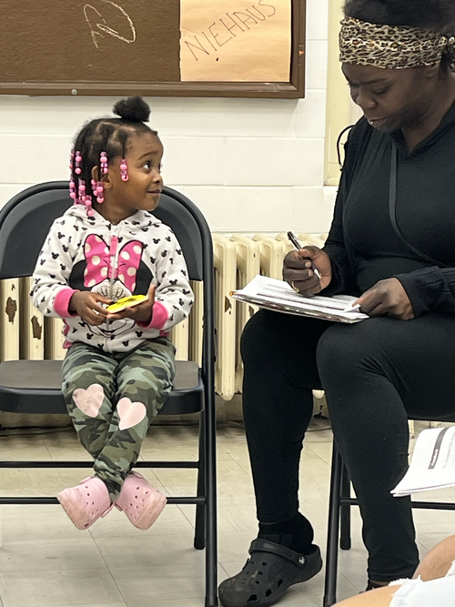 A facilitator sharing a family resource with parents